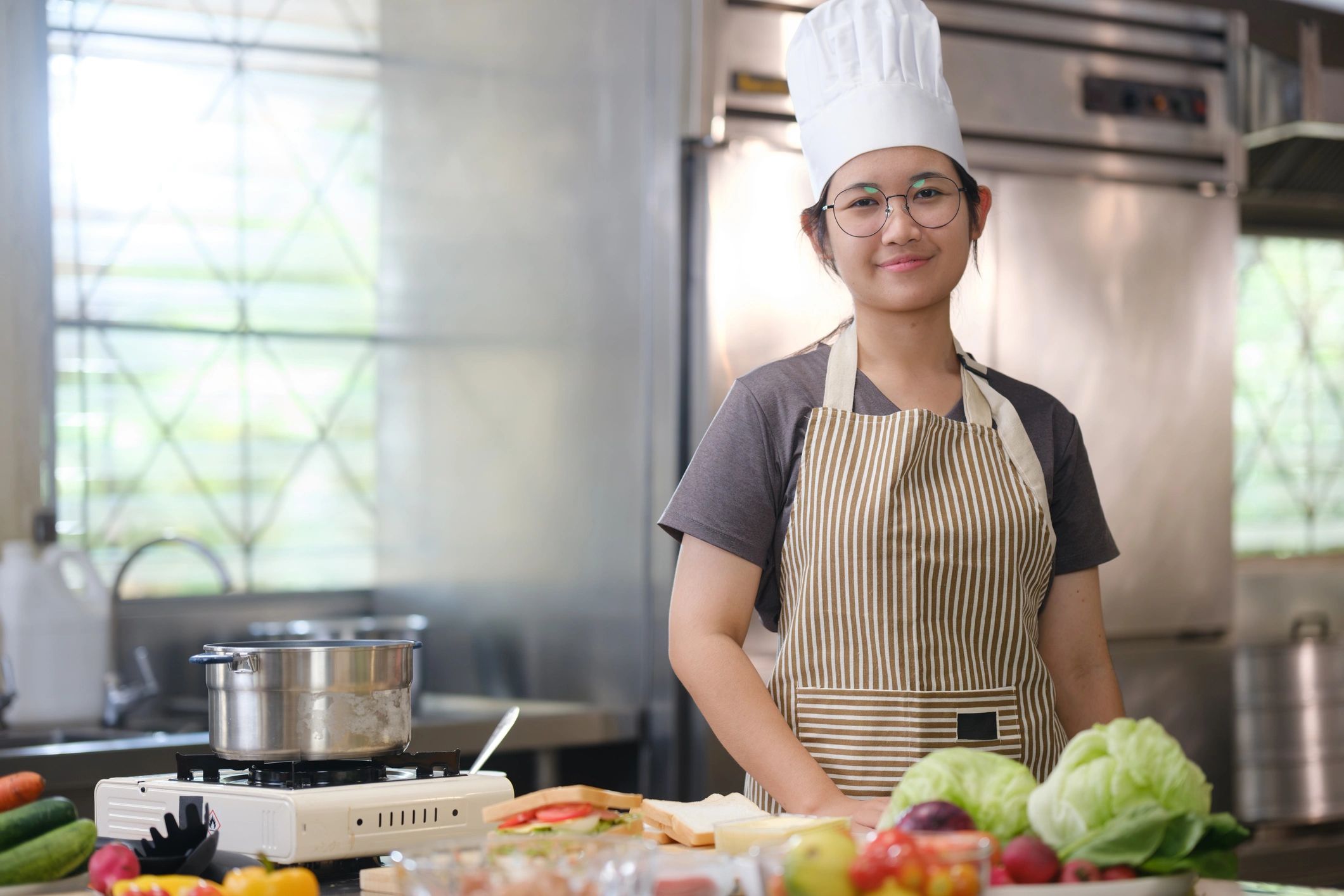 A culinary student stands in a professional training.